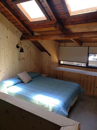 a bedroom with a bed in a wooden room at Departamento Cameron - Salepatagonia in San Martín de los Andes