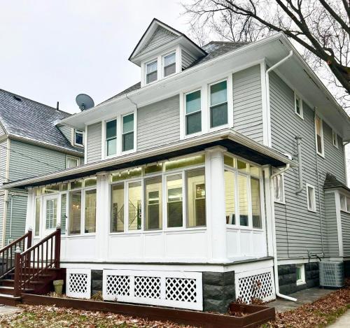a large house with a white front porch at The House Hotel Elmwood in Lakewood