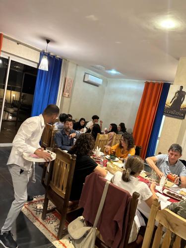 grupa ludzi siedzących przy stole jedzących w obiekcie Maison D'hôtes IMINIGRAN & Spa w mieście Warzazat