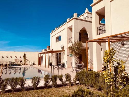 a house with a swimming pool in the desert at Maison D'hôtes IMINIGRAN & Spa in Ouarzazate