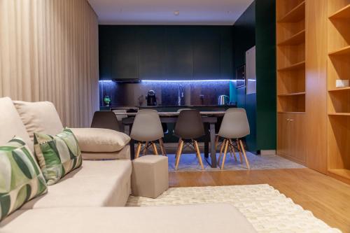 a living room with a couch and a kitchen at Poetikblue by We Do Living in Porto