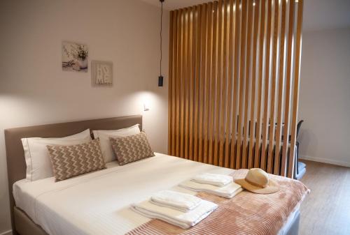 a bed with two towels and a hat on it at Poetikblue by We Do Living in Porto