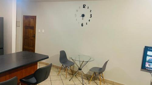 a room with chairs and a table and a clock on the wall at Damo’s Place by Mall of Africa in Midrand