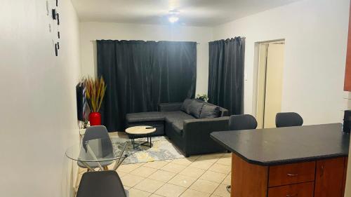 a living room with a couch and a table at Damo’s Place by Mall of Africa in Midrand
