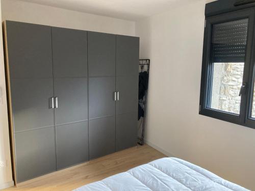 um quarto com armários cinzentos e uma janela em La Tour de l'Enversin em Vaujany