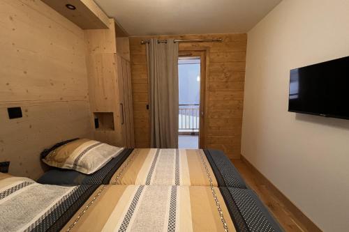 um quarto com 2 camas e uma televisão de ecrã plano em Pretty cocoon overlooking the slopes em La Plagne Tarentaise