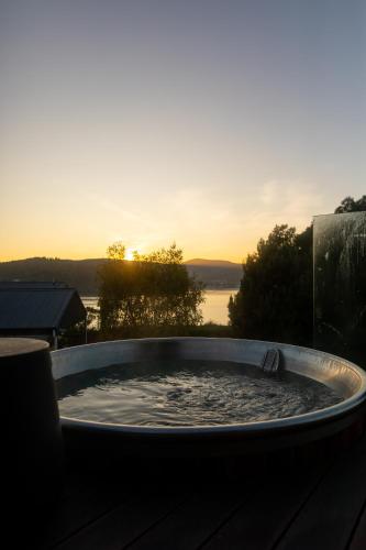 a hot tub with the sunset in the background at Woodland Bay Retreat-Hot tub,Sauna and Bayview Retreat in Lymington