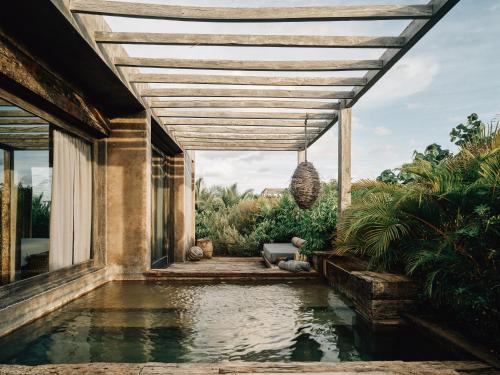 a house with a swimming pool with a pergola at Nomade Tulum in Tulum