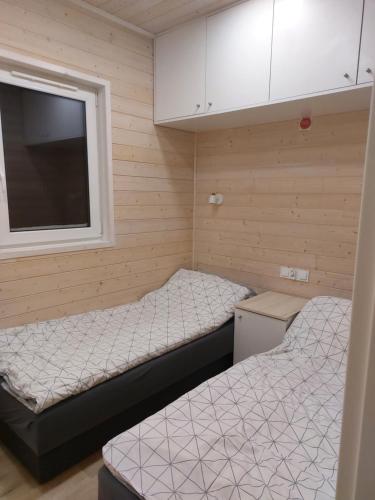 2 camas en una habitación pequeña con ventana en Domek całoroczny - Przystanek Owczarnia, 