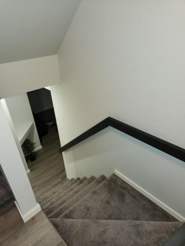 a stairway with a white wall and a white stair case at A Modern & Homely 1 BR Suite in Winnipeg