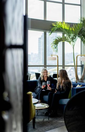 two women sitting in a room with glasses of wine at The Parker Hotel and Rooftop in Vancouver