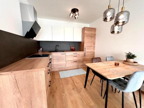 a kitchen with wooden cabinets and a wooden table at AR ALBELLI HOUSE in Košice