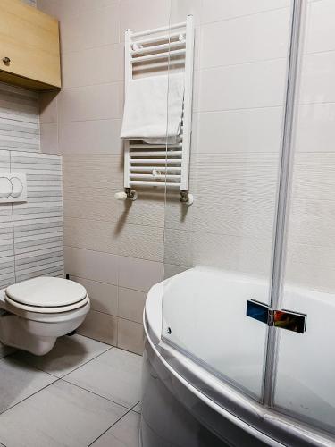 a bathroom with a toilet and a bath tub at Highrise Horizon Penthouse in Budapest