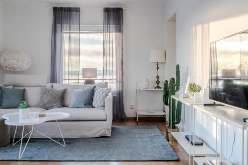 a living room with a couch and a table at Guestly Homes - 1BR Harbor View Suite in Piteå