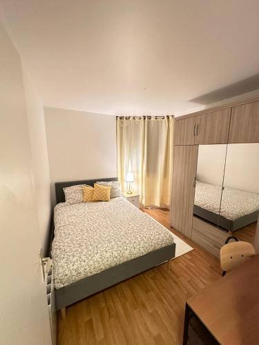 une petite chambre avec un lit et un miroir dans l'établissement Appartement en résidence- Clichy, à Clichy