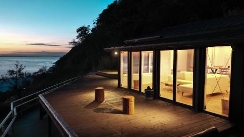 a house with a deck with a view of the ocean at 【南房テラス】180度パノラマオーシャンビュー絶景を楽しむリゾート別荘の家 in Kanaya