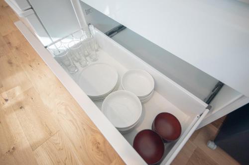 a white drawer with four bowls in it at 【南房テラス】180度パノラマオーシャンビュー絶景を楽しむリゾート別荘の家 in Kanaya