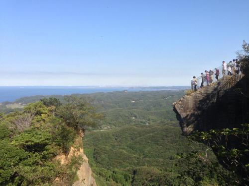 a group of people standing on the edge of a cliff at 【南房テラス】180度パノラマオーシャンビュー絶景を楽しむリゾート別荘の家 in Kanaya