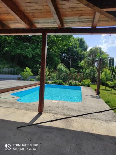 una piscina en un patio con techo de madera en Ubytování Dostál, en Vratimov