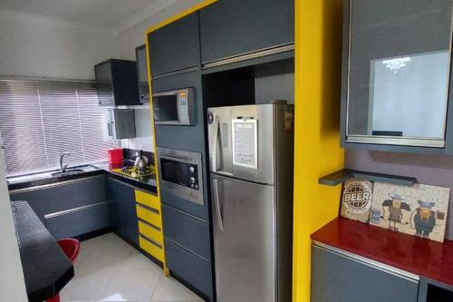 a small kitchen with a stainless steel refrigerator at Casa Itapema/SC pertinho do mar! in Itapema