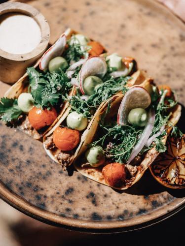 a plate with a group of food on a table at Nômade Temple Tulum in Tulum