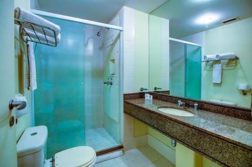 uma casa de banho com um chuveiro, um WC e um lavatório. em Linda suite em hotel ao lado do aeroporto de Congonhas em São Paulo