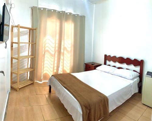 a bedroom with a large bed and a wooden ladder at Casa cinza in São Lourenço do Sul