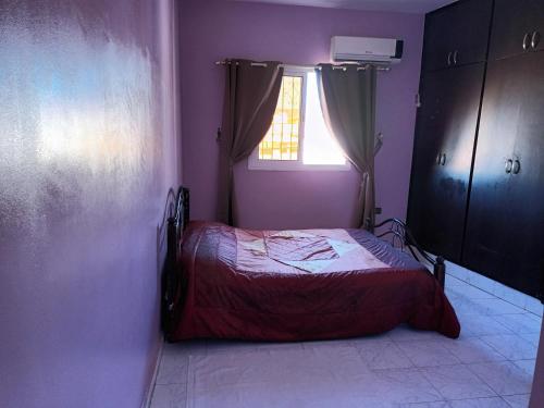 um quarto com uma cama num quarto roxo em Grand T3 meublé et propre em Agadir