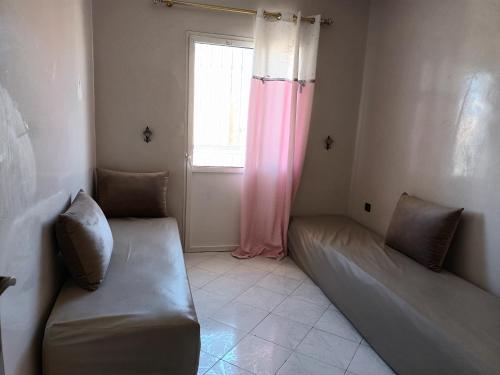 Habitación con 2 camas y ventana en Grand T3 meublé et propre, en Agadir