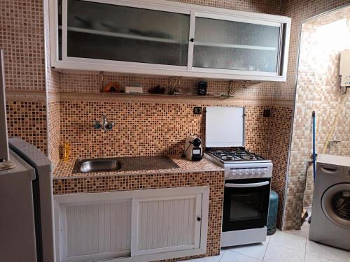 a small kitchen with a sink and a stove at Grand T3 meublé et propre in Agadir