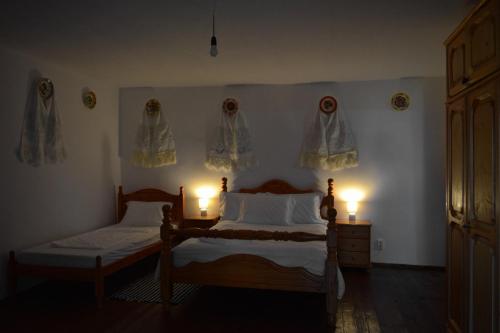 a bedroom with two beds and two candles on the wall at Casa Visovan in Sighetu Marmaţiei