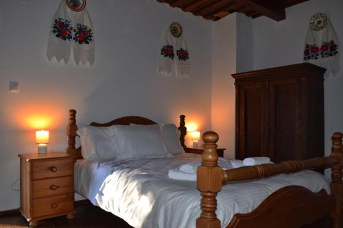 a bedroom with a bed with white sheets and two lamps at Casa Visovan in Sighetu Marmaţiei
