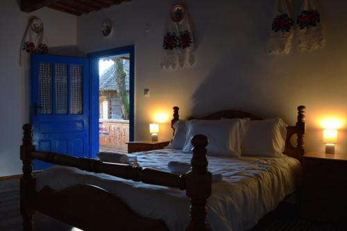 - une chambre avec un lit doté d'une porte bleue et de 2 lampes dans l'établissement Casa Visovan, à Sighetu Marmaţiei