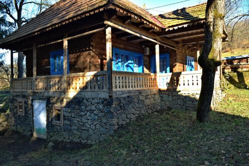 a house with a stone wall and a porch at Casa Visovan in Sighetu Marmaţiei