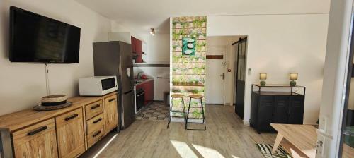 une cuisine avec réfrigérateur et une télévision dans la chambre dans l'établissement Modern seaside studio, à Fréjus