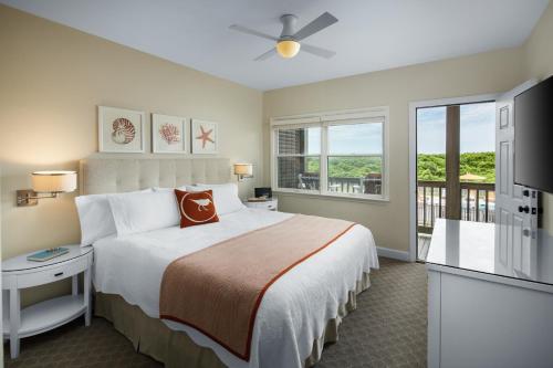 a bedroom with a large bed and a balcony at Sanderling Resort Outer Banks in Duck