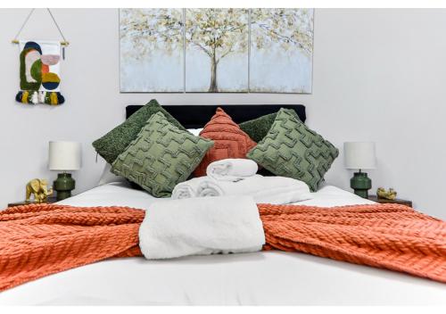 a white bed with an orange blanket and pillows at City Oasis - 1 BD Flat in Central Location in London