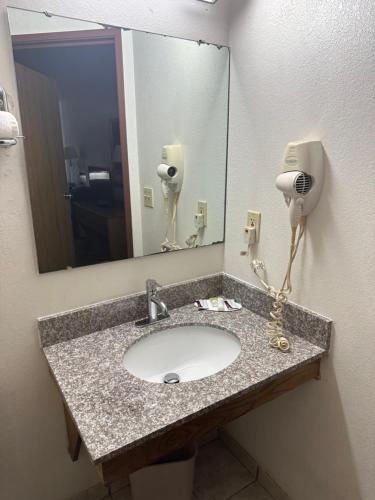 a bathroom sink with a mirror and a hair dryer at SureStay by Best Western Prince Frederick in Prince Frederick