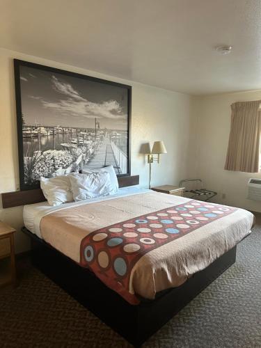 a hotel room with a large bed with a painting on the wall at SureStay by Best Western Prince Frederick in Prince Frederick