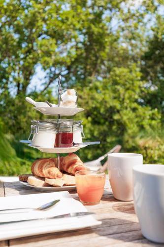 Le Mas Lauralie في Méjannes-lès-Alès: طاولة مع صحن من الكرواسون وأكواب الشاي