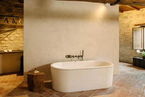 - białą wannę w pokoju ze ścianą w obiekcie Castel Di Luco w mieście Acquasanta Terme