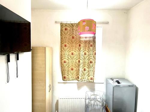 um quarto com uma janela com um candeeiro e um frigorífico em PEACEFUL PLACE em Nottingham