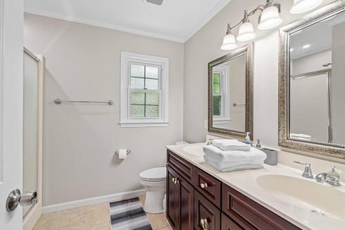 a bathroom with a sink and a toilet and a mirror at Beautiful Home Walking Distance to Elon University in Elon