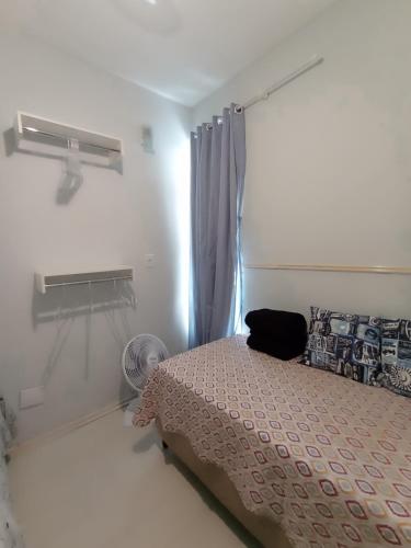 um quarto com uma cama e uma janela em Apartamento Aconchego na Praia da Costa em Vila Velha