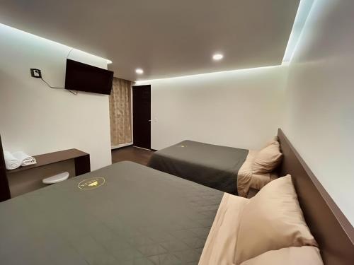 a hotel room with two beds and a television at Jovis Hotel - Lujo Cultural in Villa Aldama
