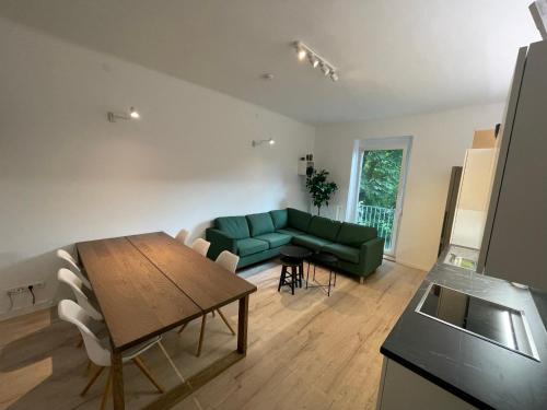 een woonkamer met een groene bank en een tafel bij City Apartment Messe Graz Amélie in Graz