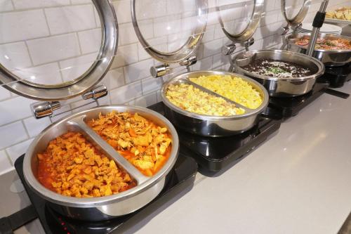 four pots of food on a counter in a kitchen at Holiday Inn Express & Suites Monterrey Valle by IHG in Monterrey