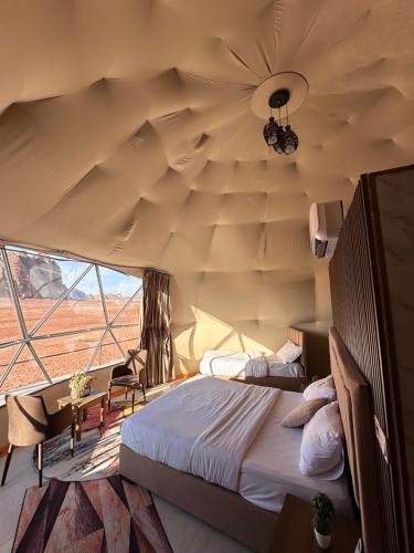 a bedroom with a bed and a large ceiling at Rum Four Seasons luxury camp in Wadi Rum