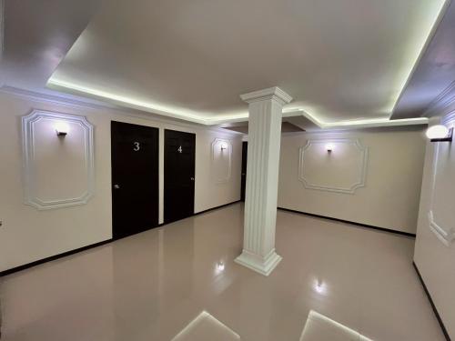 a hallway with white walls and a column in a building at Jovis Hotel - Lujo Cultural in Villa Aldama