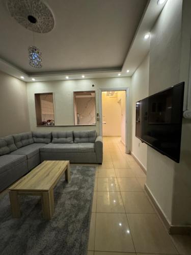 a living room with a couch and a tv at Hyat Apartments in Alexandria